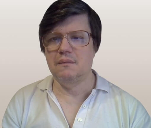 Pio Julius testvér, középkorú férfi szemüveggel, világos ingben, semleges háttér előtt, enyhén komoly arckifejezéssel.